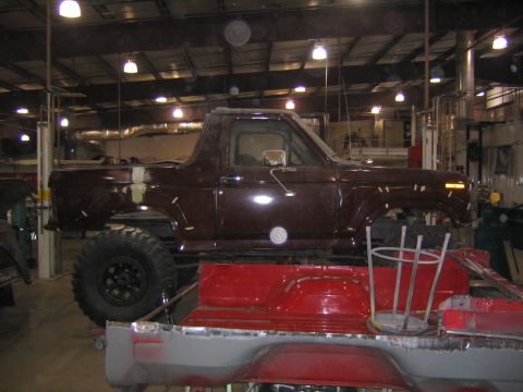 1982 Ford Bronco - A maroon 1982 Ford Bronco is seen in a workshop, possibly undergoing restoration or modification.