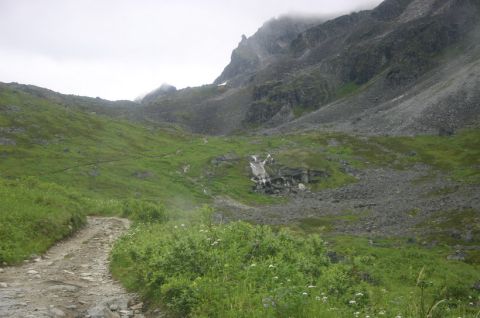 2003 Jeep TJ - A scenic mountain landscape features a winding dirt path leading towards a distant waterfall.