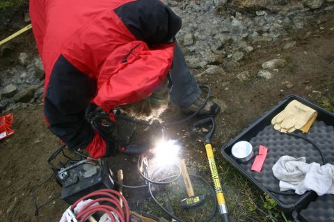 2003 Jeep TJ - Outdoor welding operation in progress with various tools and equipment laid out.
