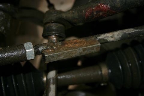 2003 Jeep TJ - Close-up view of a corroded steering linkage assembly, showing mechanical components.