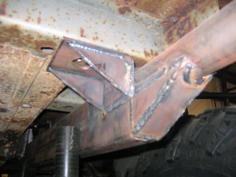 1982 Ford Bronco - Close-up view of a custom welded bracket on a vehicle's frame, showing signs of rust and modification.