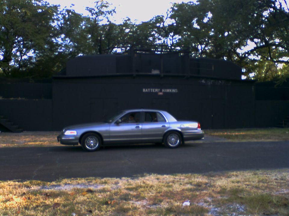 Gray Crown Victoria parked in front of a concrete Battery Hawkins coastal fortification