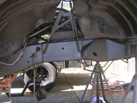 1996 Ford Bronco - Undercarriage components, including frame and suspension, are supported by jack stands. A tire is visible on the left.