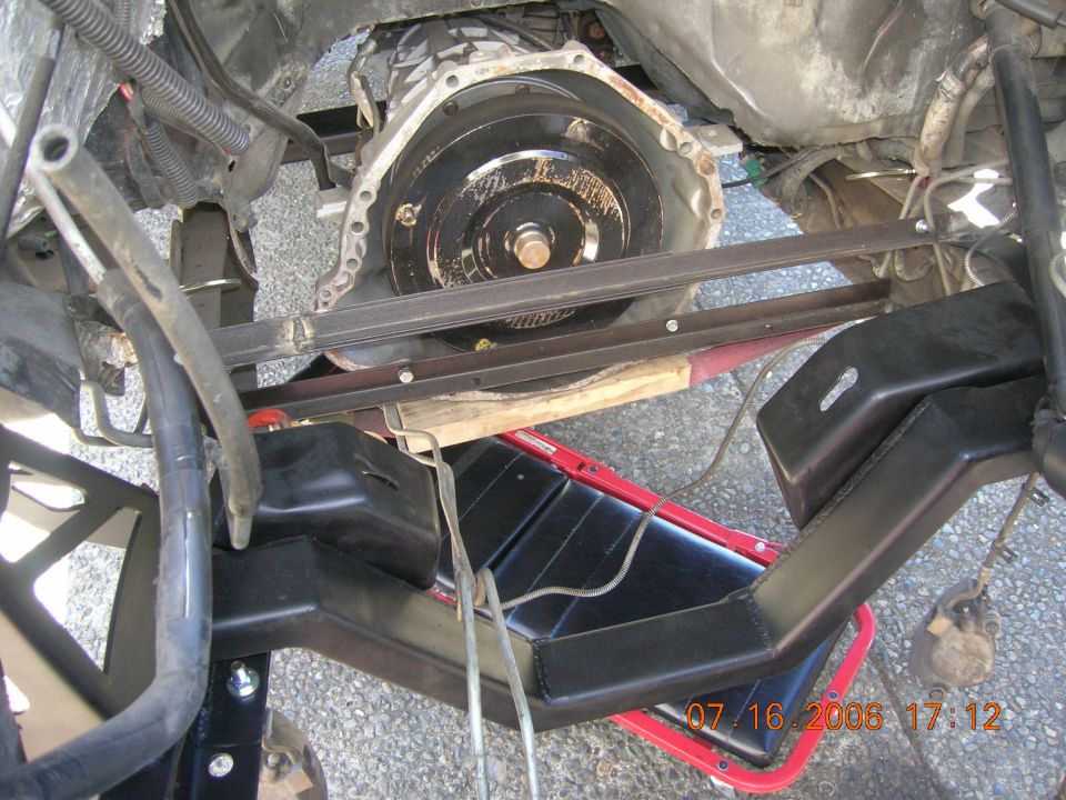 Underside view of engine bellhousing with transmission removed, red jack below