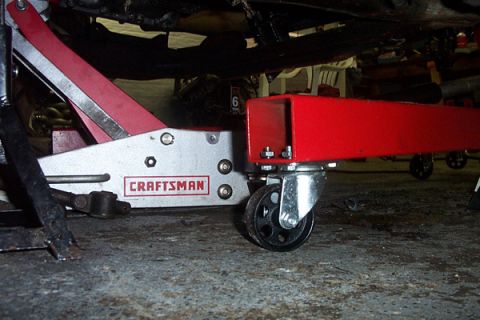 1995 Ford Taurus - Engine hoist and jack are positioned under the vehicle for support during maintenance.