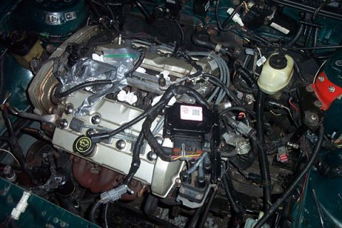 1995 Ford Taurus - A complex engine bay with numerous wires and components, suggesting a recent repair or modification.