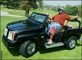 1988 Ford Bronco - Man drives a black golf cart on a golf course.