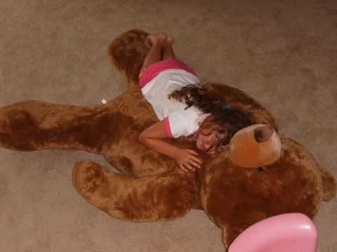 1993 Ford Bronco - A young girl is playing on a giant teddy bear in a room.