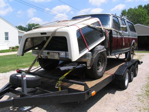 1986 Ford C-350 (Centurion Conversions) - Ford Bronco being transported on a trailer with its roof section detached and secured.