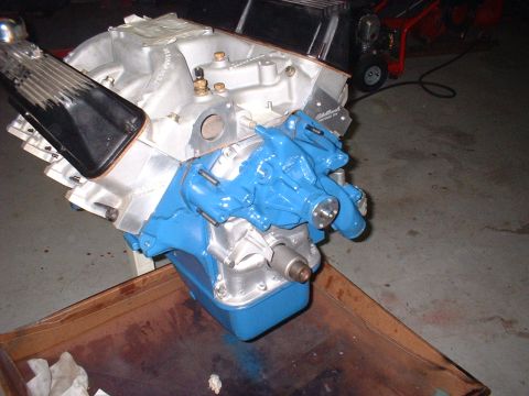1965 Shelby Cobra - A V8 engine block with a bright blue water pump and silver intake manifold is shown.