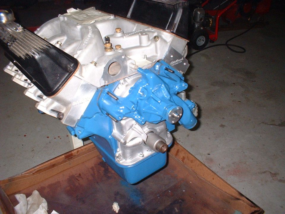 V8 engine block, blue water pump, silver intake manifold, black valve cover