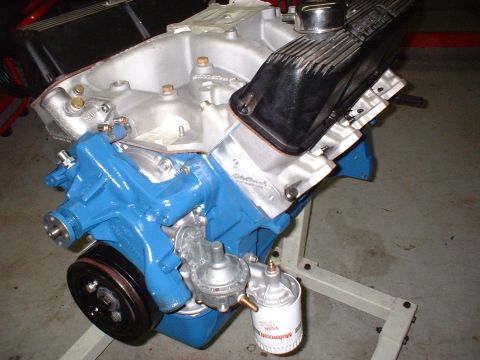 1965 Shelby Cobra - Close-up of a rebuilt engine block, showing the intake manifold, valve covers, and fuel pump assembly.