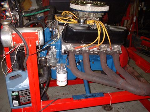 1965 Shelby Cobra - Engine on a stand, possibly a 428 CJ, with black Cobra valve covers and yellow spark plug wires.