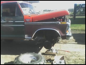 1995 Ford Bronco - Front view of a 1978 Ford Bronco with the hood up and a wheel off for maintenance.