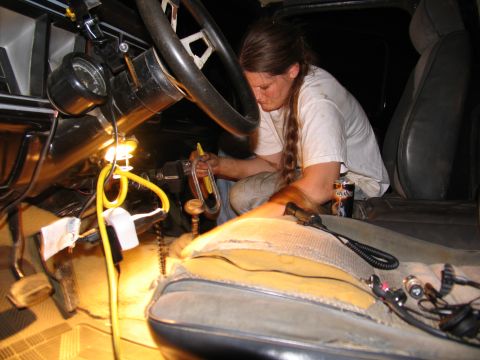 1978 Ford Bronco - A person works on the interior of a 1978 Ford Bronco, focusing on the dashboard and steering column area.