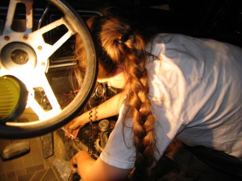 1978 Ford Bronco - A person is working on the interior of a vehicle, with their head down and focused on the task.