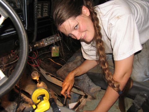 1978 Ford Bronco - A person works on the interior of a 1978 Ford Bronco, focusing on the dashboard and center console wiring.