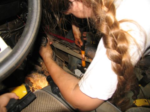 1978 Ford Bronco - Two individuals are working inside a vehicle, focusing on the transmission tunnel area.