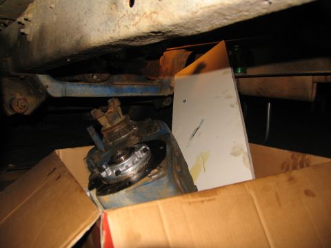 1978 Ford Bronco - A disassembled transfer case sits in a box beneath the chassis of a vehicle.