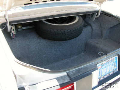 1981 Mercury Grand Marquis - The trunk of a car contains a spare tire and a license plate.
