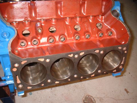 1970 Ford Torino - Engine block with four cylinders exposed, painted red and blue, ready for assembly.