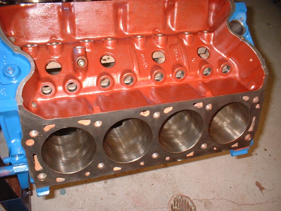 Close-up of an engine block with cylinders visible, painted red and blue
