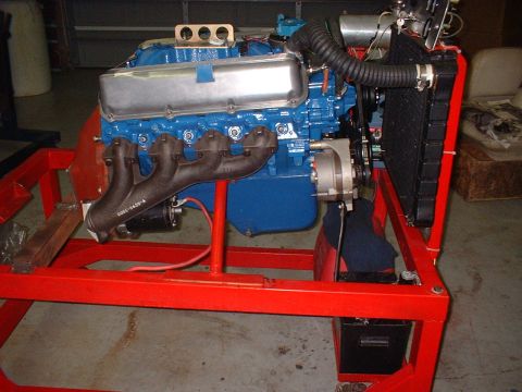 1970 Ford Torino - A V8 engine is mounted on a red stand, showing the engine block, exhaust, and radiator assembly.