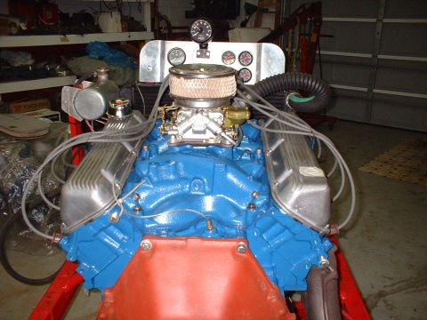 1970 Ford Torino - A blue V8 engine assembly is displayed with various gauges and an air filter. The engine is not part of a complete vehicle.