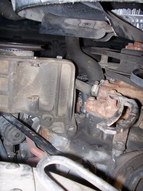 1986 Ford Bronco - This is underneath looking up. The alt goes on that bracket (left center) and the bottom attaches to the swing arm (right center). The air…