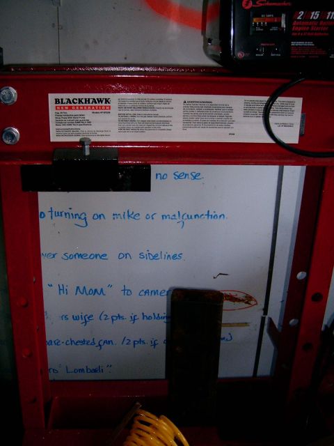 1986 Ford F-250 - A red hydraulic press is shown with a whiteboard covered in handwritten notes and diagrams.