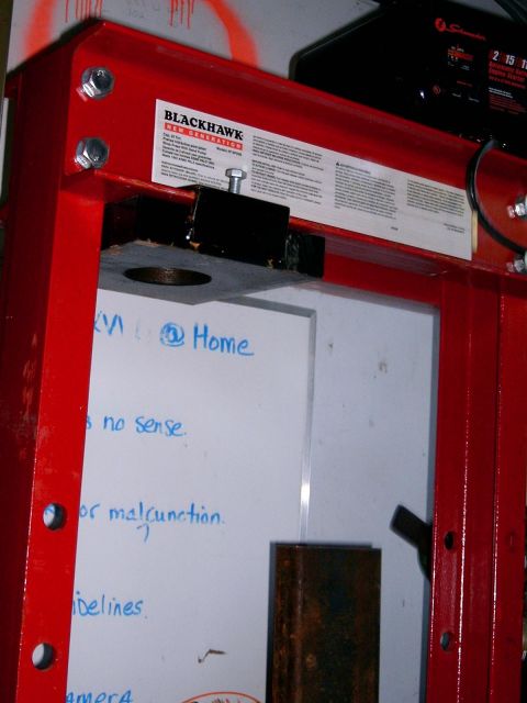 1986 Ford F-250 - Close-up of a red Blackhawk shop press, with text visible on a label and a whiteboard.