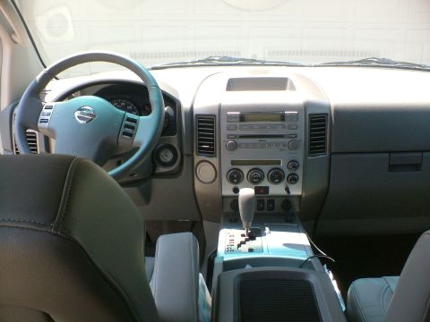 2006 Nissan Armada - The interior of a car shows the steering wheel, dashboard, and center console with a gear shifter.