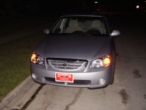 1996 Ford F-150 - A silver sedan is parked at night, facing the camera with its headlights on.