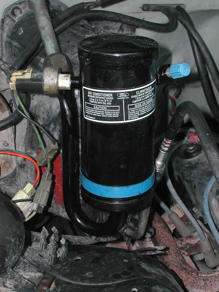 Now I put the new accumulator ($49.99) on and also the new orifice tube ($2.95) in the bottom tube of the evaporator. Next I checked all the connections and reconnected the guage set. I then ran the vacumm pump for about 3 min to get a vacuum reading of 29". At this point close both valves on the guage set, turn off the vacuum pump and go have another beer. Wait 15 min or so and check to see if the system held the vacuum. In my case no problem, but if the vacuum dropped first step is to close the service valves on the back of the compressor and repeat the test. If it holds that time the leak is in the compressor, if not it's in one of the lines, connections, or coils. If there are no leaks, it's time for the 3 step evacuation.
