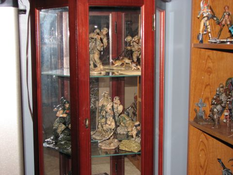 1991 Ford Bronco - A wooden display cabinet filled with various military-themed action figures and dioramas.