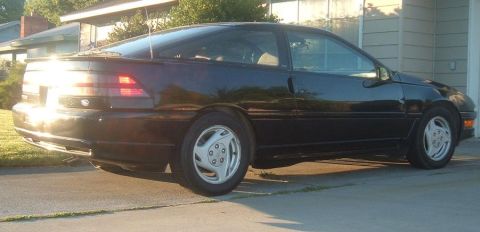 1991 Ford Probe - Black 1991 Ford Probe coupe seen from the rear quarter angle in a driveway.