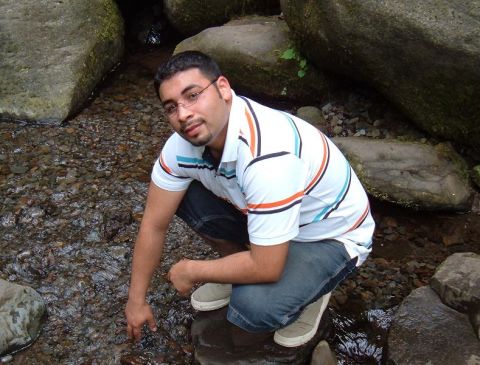 1991 Ford Probe - A man kneels by a shallow stream, surrounded by large rocks and foliage, with a website watermark visible.