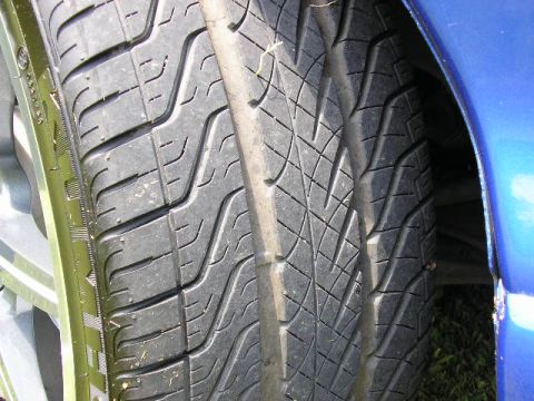 1994 Ford Probe - A close-up view of a tire and the fender of a blue vehicle.