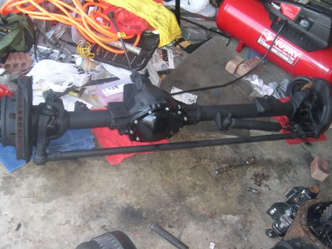 1980 Chevrolet Blazer - A disassembled front axle assembly is laid out on the floor, surrounded by tools and other garage items.