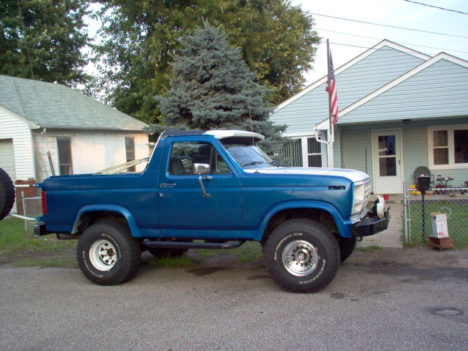 Blue lifted Ford F-150 4x4 short-bed on chrome wheels parked on a side street