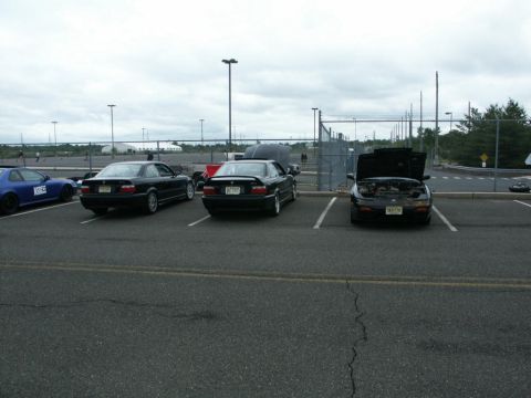 2001 Mercury Grand Marquis - A group of cars are parked in an outdoor lot under an overcast sky.