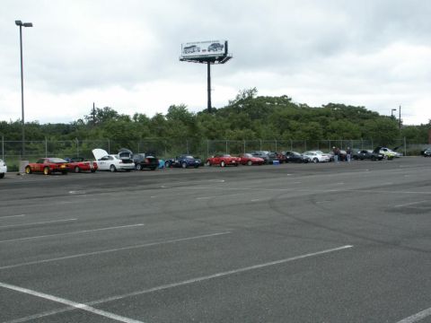 2001 Mercury Grand Marquis - Several cars are parked in a lot, with some people gathered around them.