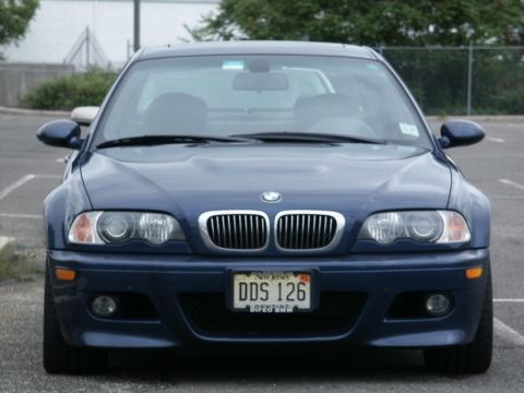 2001 Mercury Grand Marquis - Blue BMW sedan parked in a lot, front view shows grille and headlights.