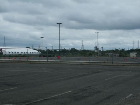 2001 Mercury Grand Marquis - An overcast sky looms over an empty parking lot marked with orange cones and a fence.