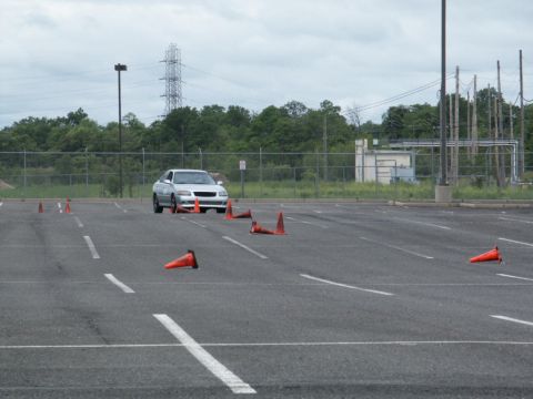 2001 Mercury Grand Marquis - A silver sedan maneuvers through a cone course in an empty parking lot, likely during a driving event.
