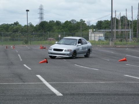 2001 Mercury Grand Marquis - A silver sedan navigates a course marked by orange cones on a cloudy day.