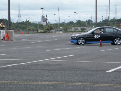 2001 Mercury Grand Marquis - A black sedan with blue accents navigates a course marked by traffic cones in an empty parking lot.