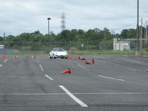 2001 Mercury Grand Marquis - A white sports car navigates a cone course in an empty parking lot.