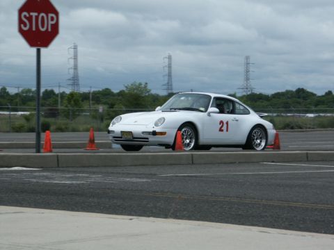 2001 Mercury Grand Marquis - White Porsche 911 with racing number 21 on the door, seen in a parking lot with cones.