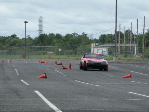 2001 Mercury Grand Marquis - Sports car driving through a cone course in an open lot.